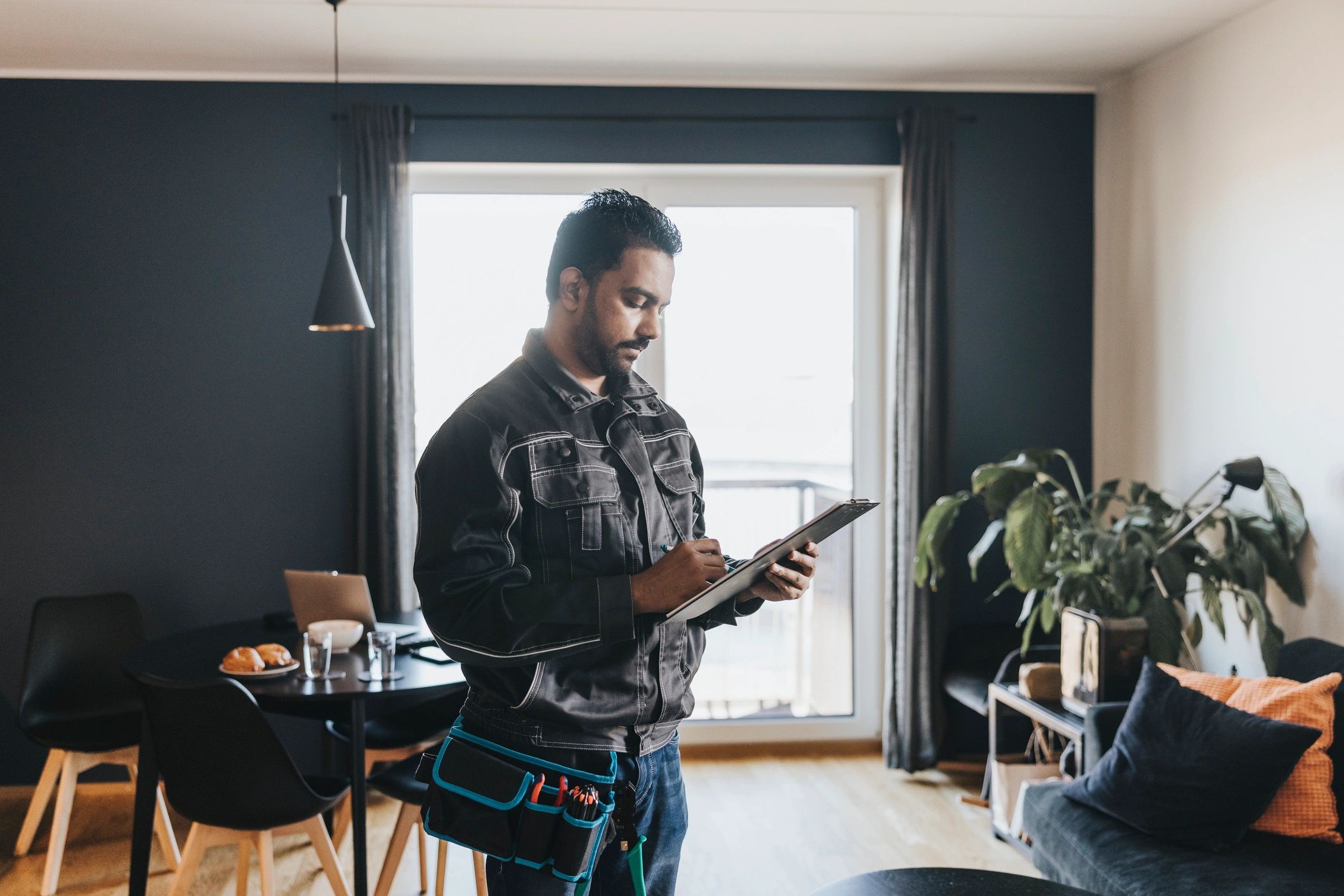 Technician writing service checklist during an HVAC maintenance visit