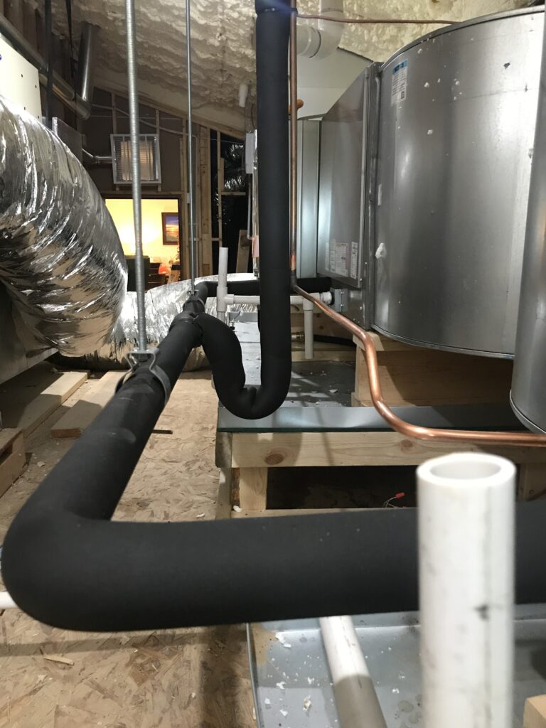 New large air handler and refrigerant lines in an attic at a customers house in San Angelo.